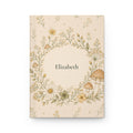 Wildflower and Mushroom personalized journal open flat showing custom name on cover with floral wreath illustration